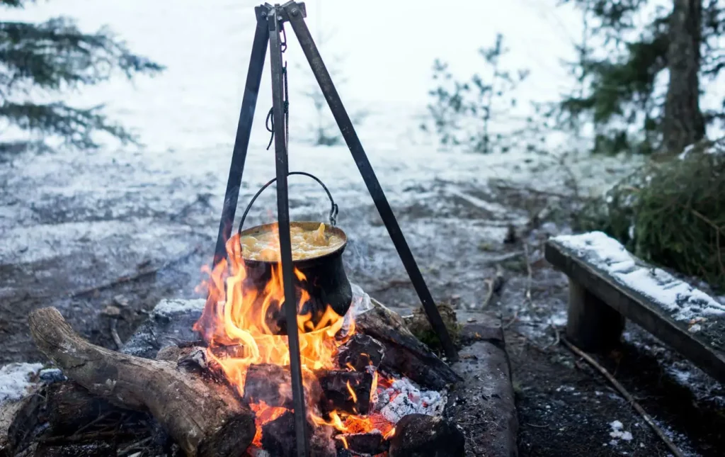 Stainless steel cooking pot over a campfire