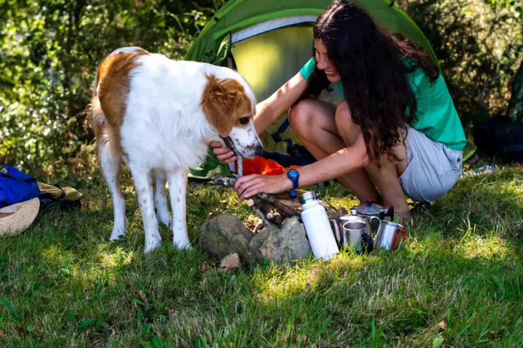 Woman petting her dog at campsite