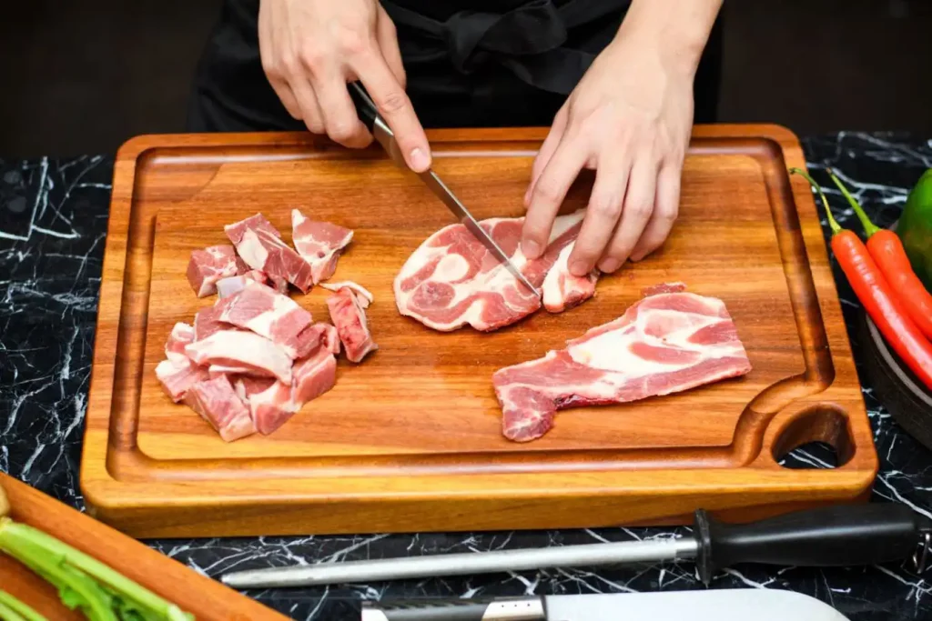 Hand cutting steak on chopping board
